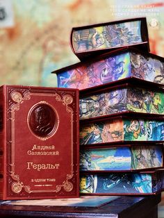 a stack of books sitting on top of a wooden table next to a red box