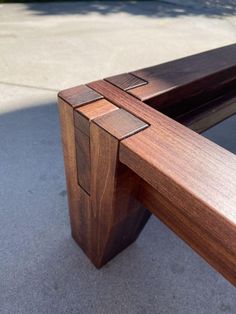 a wooden bench sitting on top of a sidewalk