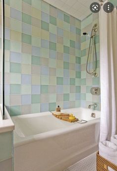 a bath tub sitting under a window next to a shower head mounted faucet