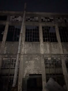 an old building with broken windows at night