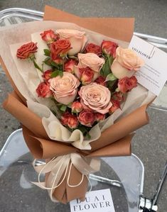 a bouquet of roses is wrapped in brown paper