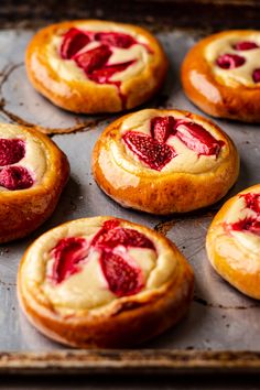 freshly baked pastries with strawberries in them on a baking sheet, ready to be eaten