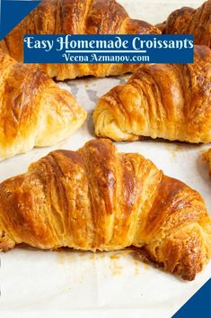 some croissants sitting on top of a piece of parchment paper with the words homemade croissants above them