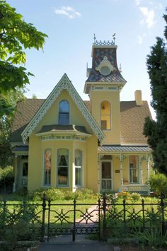 a large yellow house with a clock tower