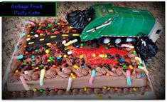 a birthday cake decorated with candy, candies and a green truck on it's side