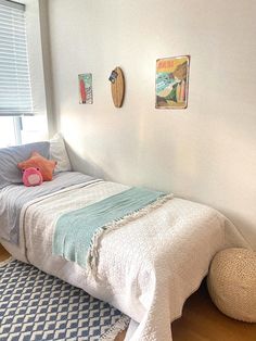 a bedroom with a bed, rugs and pictures on the wall