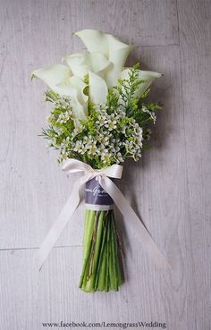 a bouquet of white flowers tied to a ribbon