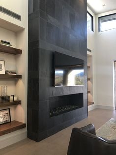 a living room with a black fireplace and shelves