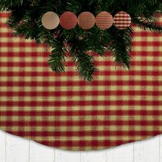 a red and white checkered table cloth with christmas ornaments hanging from the tree branch