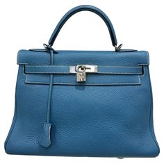 Bag by Hermès, Kelly model, size 32, made in Clemence leather, soft and textured to the touch, in the Blue Izmir colorway, with silver hardware. Equipped with the classic flap with interlocking closure with horizontal band, padlock and keys. Equipped with a central handle for carrying by hand and hooks with a thin removable leather shoulder strap. There are several internal pockets. Year of production 2006. It is in excellent condition. Hermes Blue, Hermes Kelly Bag, Structured Shoulder, Kelly Bag, Hermes Handbags, Classic Flap, Handle Bag, Silver Hardware, Fashion Handbags