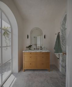 a bathroom with two sinks and a large mirror on the wall next to an arched doorway