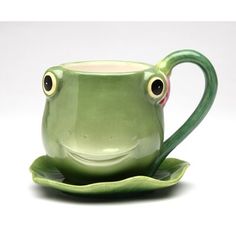 a green ceramic cup and saucer with two eyes