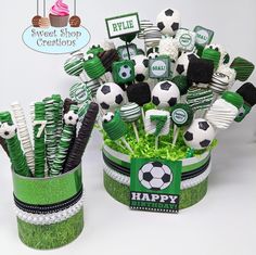 a green and white cup filled with lots of soccer themed candy sticks on top of grass