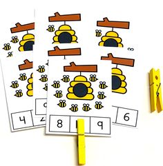 three bee themed cut outs on top of a white table with yellow pegs next to them