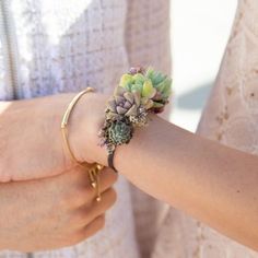 a close up of a person wearing a bracelet with flowers on it