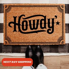 a person standing in front of a door mat with the word hodgy on it