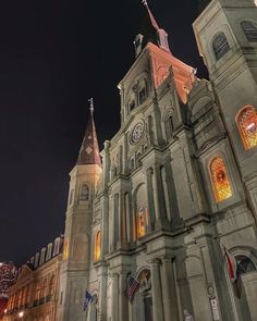 an old church lit up at night with american flags flying in the wind and lights on