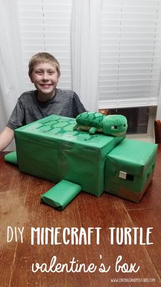 a young boy sitting in front of a box shaped like a turtle with the words diy minecraft turtle valentine's box written on it