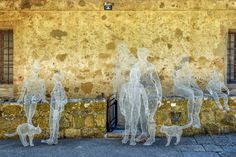 an image of some people and a dog in front of a building that is painted yellow