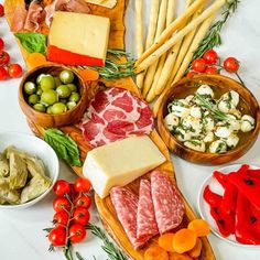 an assortment of cheeses, meats and vegetables on a table