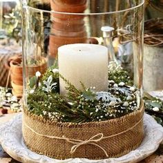 a table topped with a glass vase filled with candles