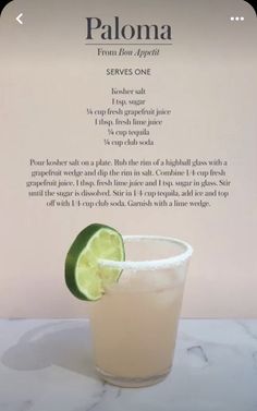 a drink with a lime slice on the rim in front of a menu for paloma