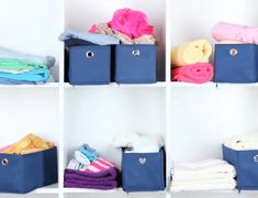 towels and blankets are stacked on shelves in a room with blue bins filled with folded clothes