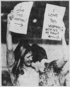 two women holding up signs that say love this woman with all my heart and i love this woman