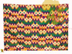 an orange, green, yellow and red pattern is on the back of a large piece of fabric