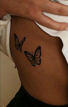 a woman's stomach with two butterflies on it and the bottom part of her belly