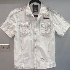 Super Cool & Edgy Distressed White Shirt! Very Well Made And Tailored. They Don't Make Shirts Like That Anymore! Designed With Western-Style Embellishments, Snap Buttons, Logos, Front Pockets, Black Contrast Stitching, And A Relaxed Fit. Versatile, Will Look Amazing With Any Outfit. Very Comfy, Made Of High-Quality Sturdy Yet Breathable 100% Cotton Treated To Create Superb Vintage Look & Washes To Fabric Approx: Pit To Pit 21", Sleeve 8.5", Length 25". Nwot From A Clean, Smoke-Free Home. White T-shirt With Button Closure For Spring, White Button-up Summer T-shirt, White Short Sleeve T-shirt With Buttons, White Fitted Short Sleeve Shirt With Buttons, Fitted White Short Sleeve Shirt With Buttons, White Cotton T-shirt With Button Closure, White Short Sleeve Tops With Pockets, White Fitted Short Sleeve Casual Shirt, White Short Sleeve Shirt With Pockets For Spring