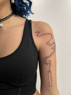 a woman with blue hair has a tattoo on her arm and is wearing a black bra