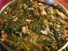 a pot filled with greens and meat on top of a stove