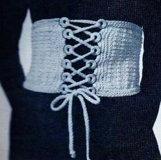 a close up of a person wearing a sweater with laces on it