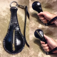 a hand holding a black leather purse with zippers on the side and inside it