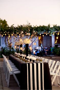 a long table set up with black and white striped linens