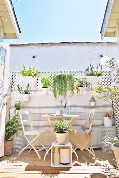 an outdoor patio with potted plants and chairs