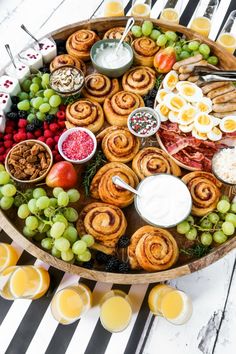 a platter filled with fruit, pastries and other food on top of a table