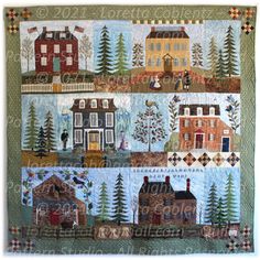 a quilt with houses and trees on it