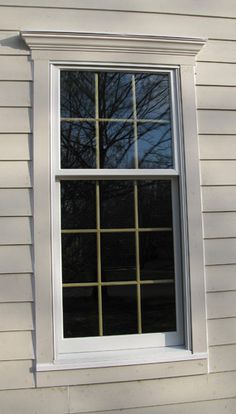 a white window sitting on the side of a house