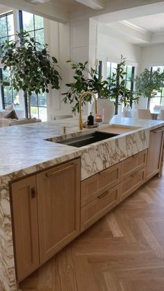 a kitchen with marble counter tops and wooden cabinets