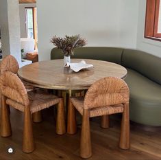 a wooden table with chairs around it in a room next to a couch and window