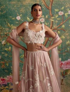 Elevate your ethnic elegance with net embroidered sleeveless blouse paired flawlessly with an organza placement embroidered lehenga and complemented by an organza embroidered dupatta. The intricately embroidered lehenga boasts delicate ivory details and enchanting 3d florals, creating a set that exudes feminine grace. Perfect for special occasions and celebrations, this ensemble effortlessly blends tradition with contemporary style. Immerse yourself in the exquisite craftsmanship and timeless de Dusky Pink Lehenga, Dusky Pink Dress, Wedding Fits, Ridhi Mehra, Lehenga Pattern, Lehenga Dupatta, Organza Lehenga, Indian Bridal Photos, Net Blouses