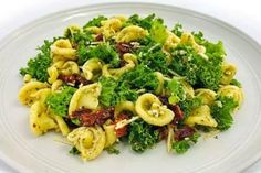 a white plate topped with pasta and broccoli