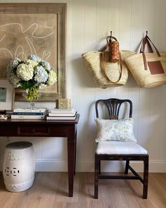 a chair and table in a room with two hats hanging on the wall above it