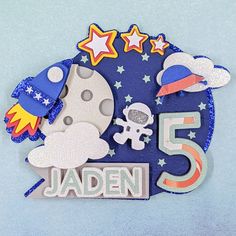 a close up of a birthday card with the number five and space related items on it