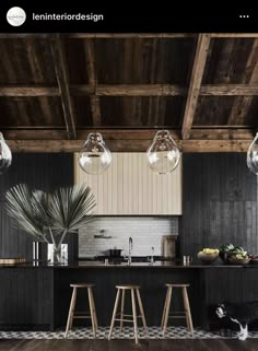 an instagramted photo of a kitchen with black cabinets and wood flooring on the walls