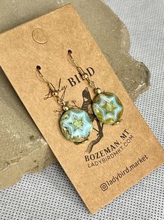 Czech glass coins in a rustic turquoise finish with an etched star centerpiece. These nature-inspired glass dangle earrings are perfect for a glam beachy look, boho shimmer, and vintage-inspired styles. Bohemian Starfish-shaped Turquoise Jewelry, Bohemian Turquoise Starfish Jewelry, Handmade Turquoise Starfish Jewelry, Bohemian Star-shaped Nickel-free Jewelry, Vintage Turquoise Czech Glass Earrings, Artisan Turquoise Czech Glass Earrings, Artisan Czech Glass Turquoise Earrings, Bohemian Star-shaped Nickel-free Earrings, Bohemian Star-shaped Adjustable Earrings