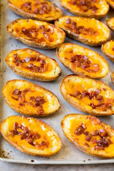 baked potato skins with cheese and bacon on a baking sheet ready to be cooked in the oven