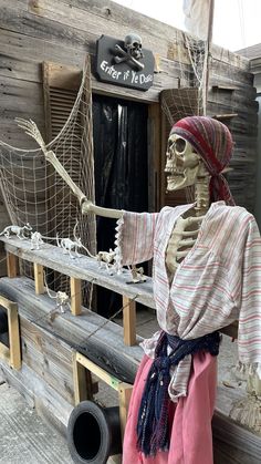 a skeleton dressed as a pirate pointing at the ship's roped in display